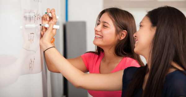 Students working math problems on whiteboard