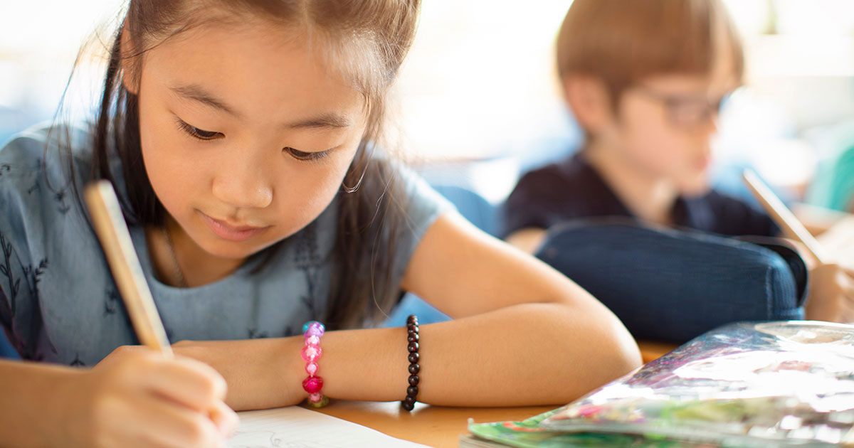 Young student writing at a desk