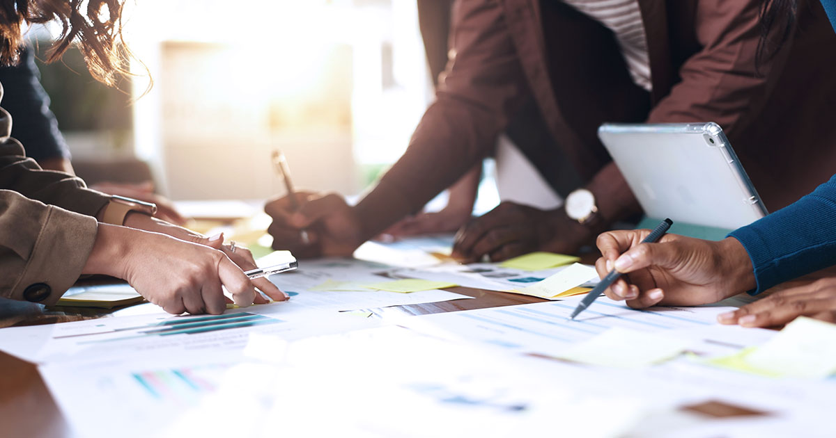 A group of educators reviewing spreadsheets at a table