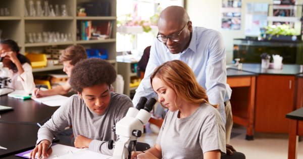 High school teacher with two students in biology class