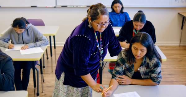 Teacher with students in high school classroom