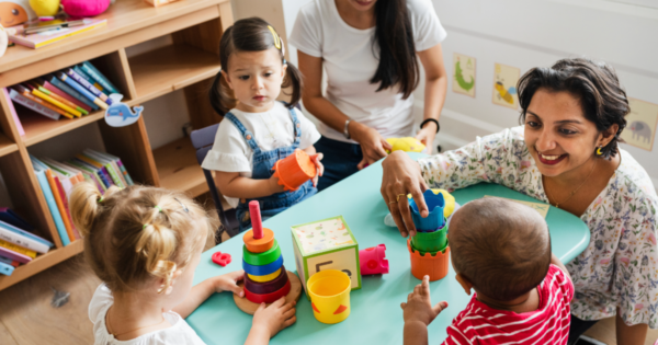 A preschool teacher and her students learning in a classroom