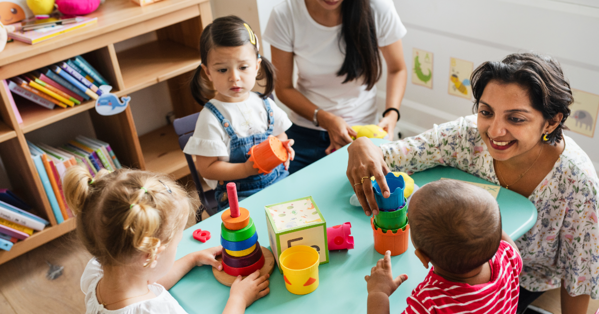 A preschool teacher and her students learning in a classroom